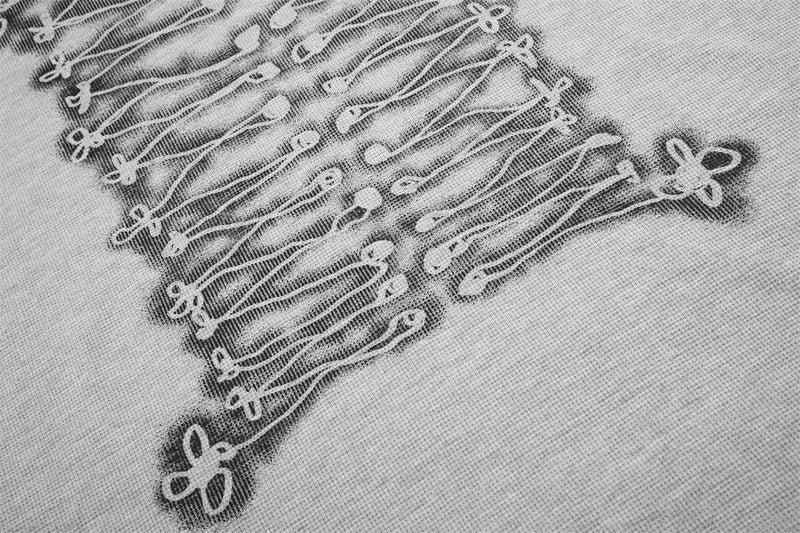 Close-up of gray tee lower front graphic with rope-knot lace-up print and floral knot ends