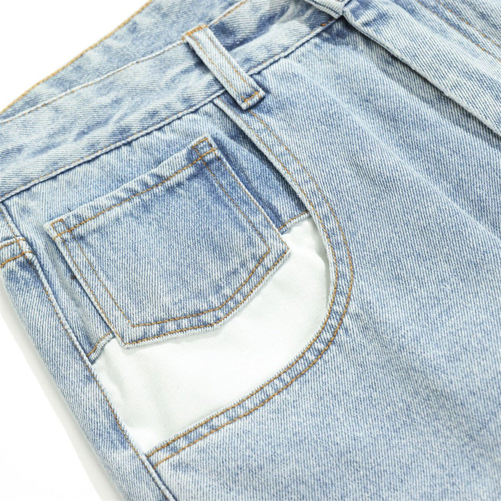 Close-up of front pocket on light wash jeans with contrast white panel