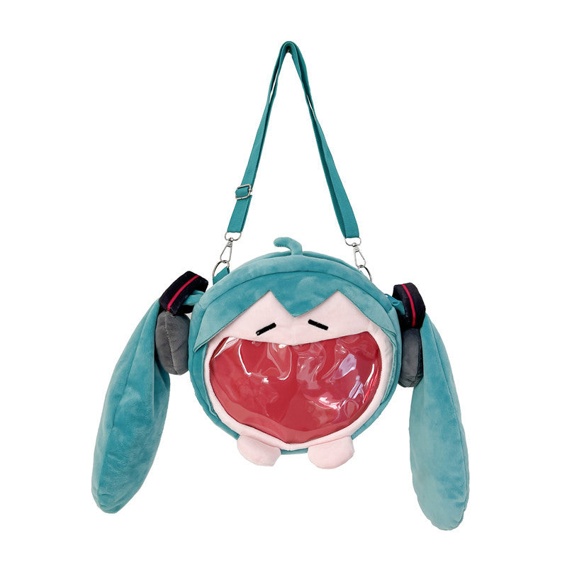 The Seakoff Cute Anime Hatsune Miku Backpack is a teal plush ita bag with a character design featuring long ears and headphones. It has a clear, mouth-like opening for displays and an adjustable, detachable strap, perfect for carrying small items in an anime-inspired style.