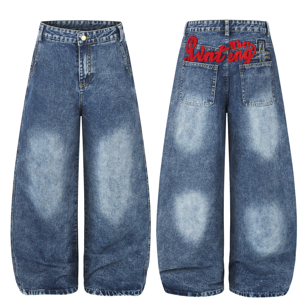 Jean homme bleu délavé à l’acide, coupe ample et forme barrel, broderie rouge façon signature sur la ceinture arrière, vues avant et arrière