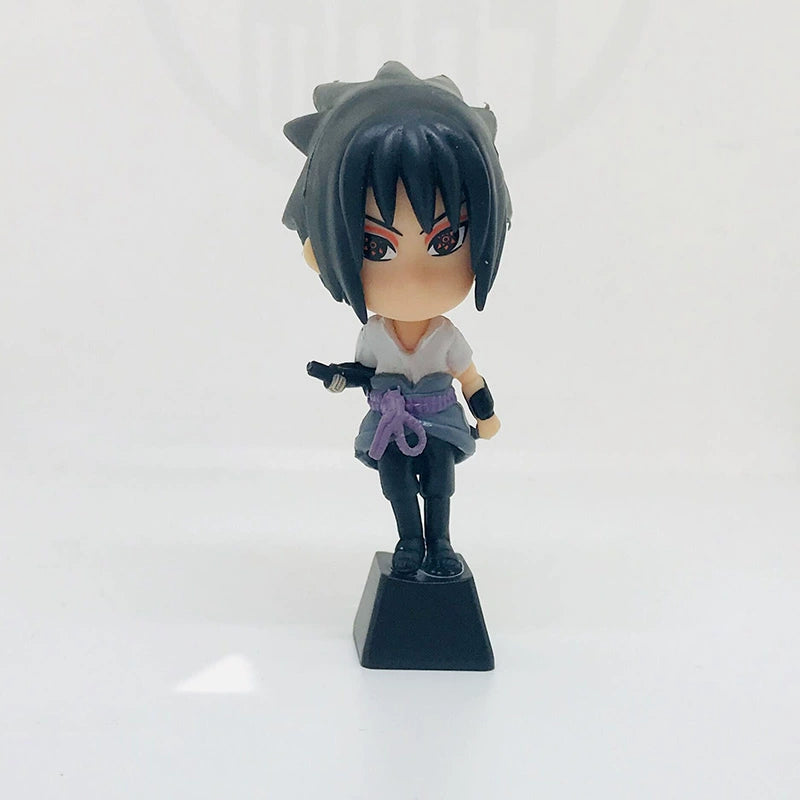 Chibi-style figurine with spiky black hair, red eyes, and a black and white outfit with a purple belt, wielding a small sword on a black base. It&