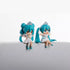 Two Hatsune Miku Prayer Hugging Angel Princess figures, each 7.5cm and made of PVC, are set on a white surface against a plain background. They have teal hair, wear white dresses with matching shoes, and are adorned with crown-like accessories; one&