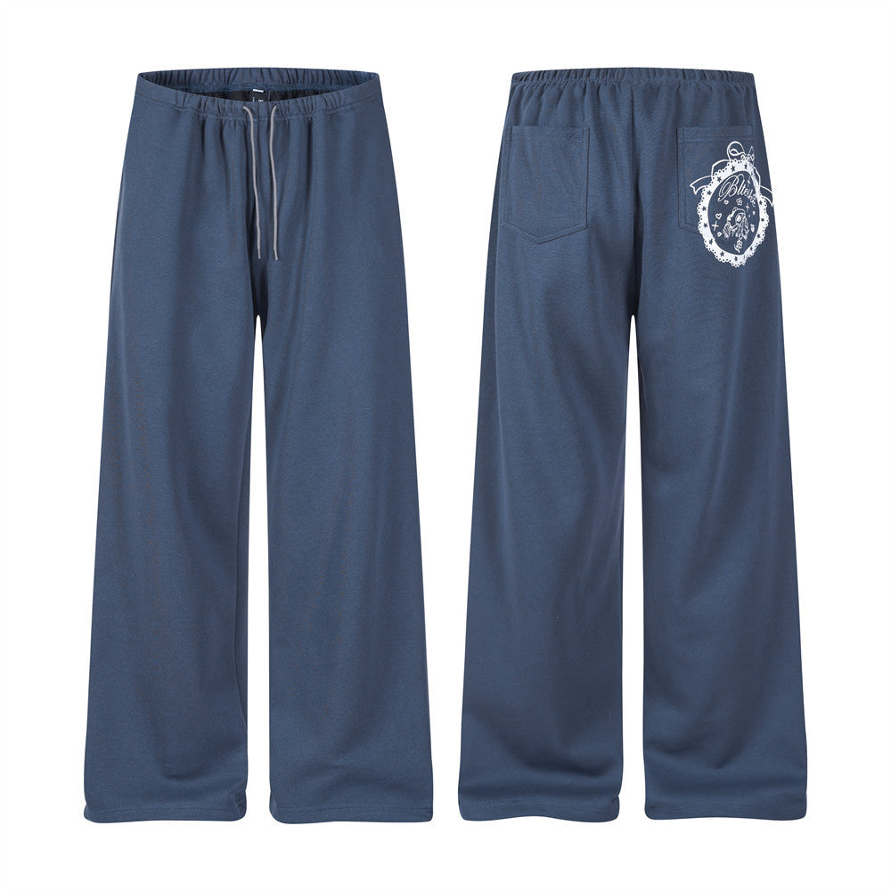 Front and back views of navy wide-leg track pants with drawstring waist and white back pocket print