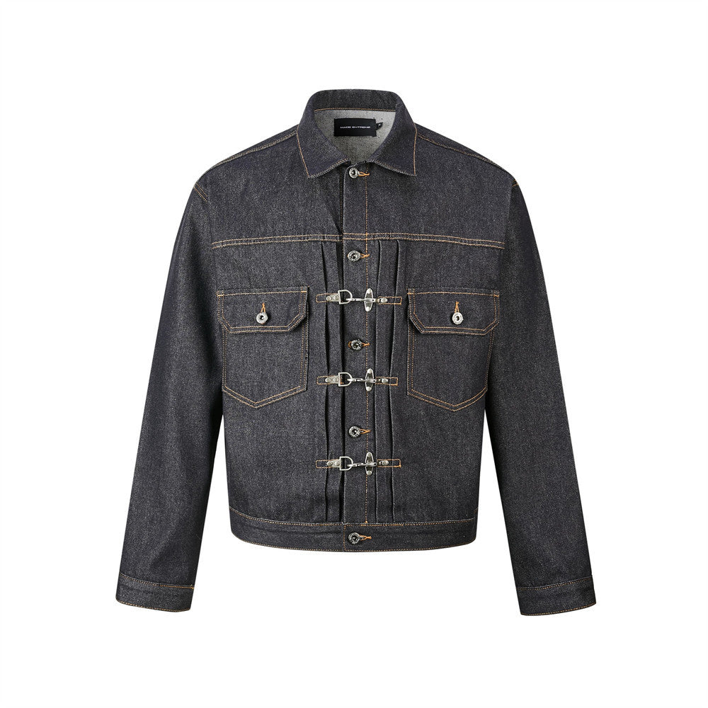 Men's dark indigo denim trucker jacket with silver metal buckle clasps and pleated front panel, contrast orange topstitching