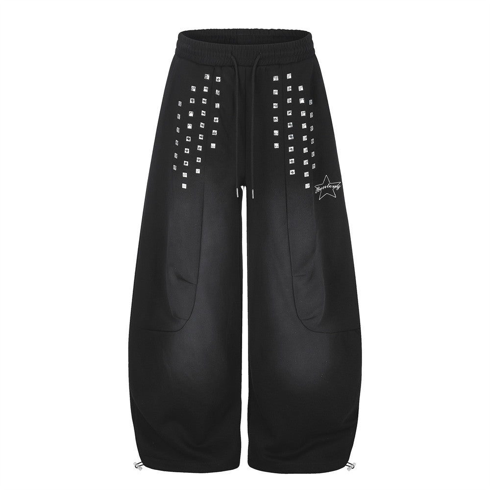 Wide-leg black sweatpants with square silver stud embellishments and star logo embroidery on the front thighs