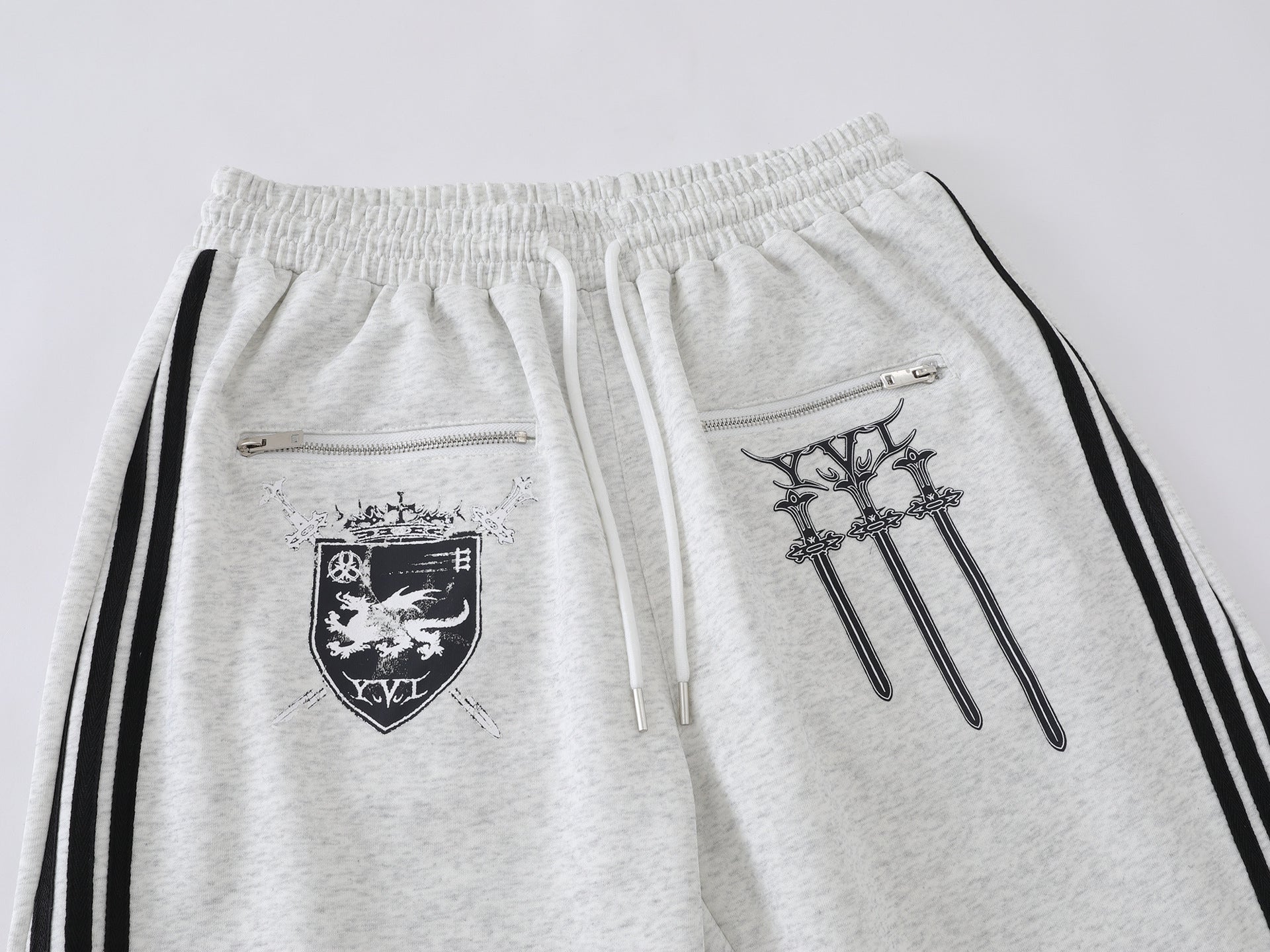 Pantalon de survêtement à jambes larges avec graphisme héraldique et détails latéraux multibandes