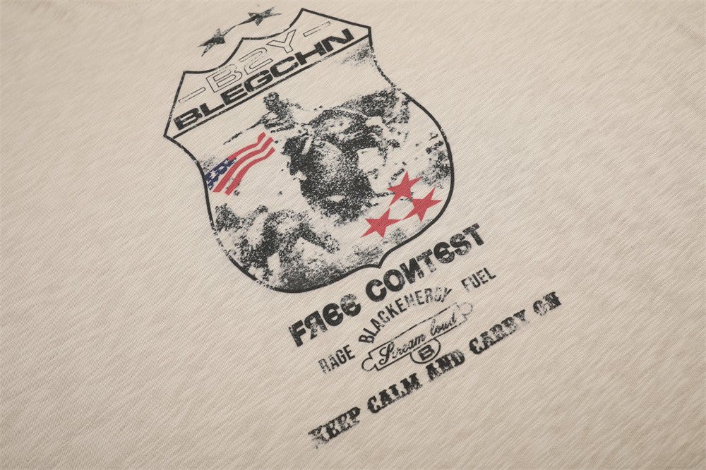 Close-up of beige tee front graphic and printed text below the badge design