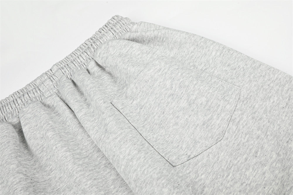 Close-up of gray sweatpants back pocket and waistband stitching