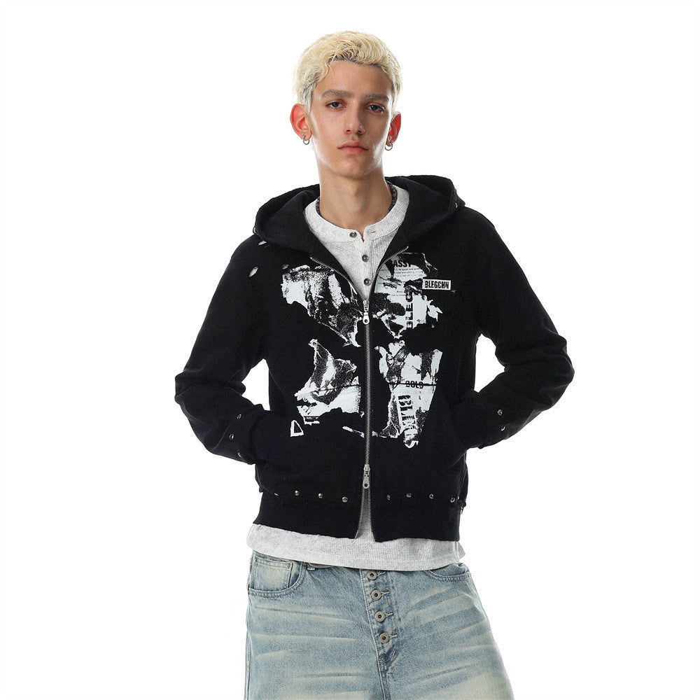 Men's black zip up hoodie with abstract collage graphic print, metal stud hem detail, and distressed finish