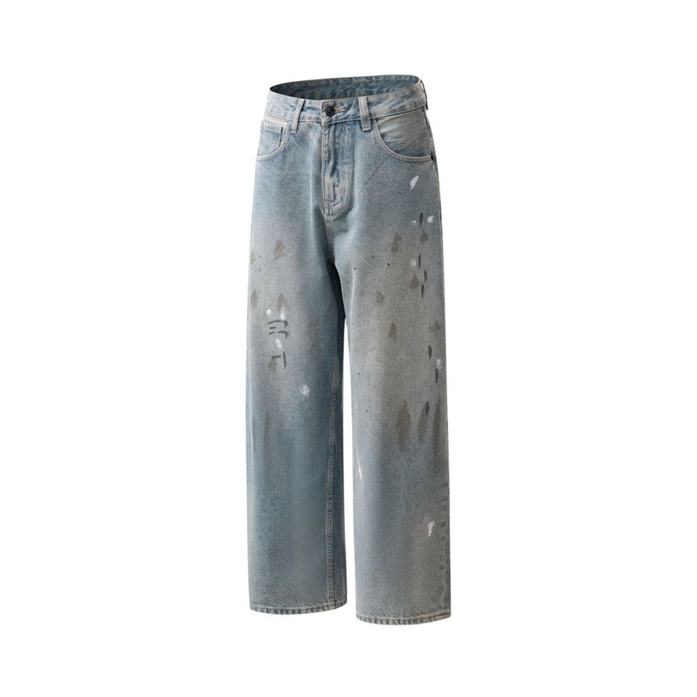 Angled front view of wide leg faded blue jeans with paint splatter marks