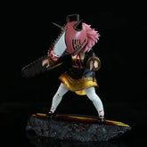 The Chainsaw Man Anya Forger PVC Figure by Spy × Family is a 17.5 cm collectible statue featuring a pink-haired character in Chainsaw cosplay, sporting a gold and black outfit. The design includes a red-stained chainsaw head set against a textured black base for striking contrast.