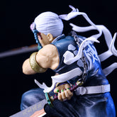 The Uzui Tengen Action Figure from Demon Slayer, standing 14CM, captures the essence of the Sound Hashira in a dynamic pose. It features a sword, white hair with a headband, sleeveless blue top with white writing, flowing ribbons, decorative bracelet on the right arm, and visible chain.