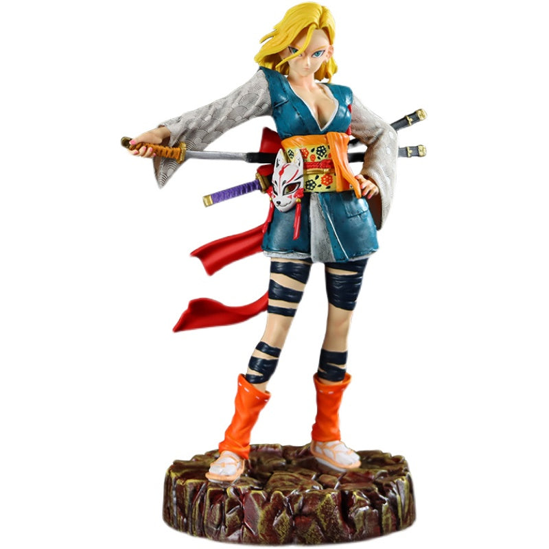 The Seakoff Android 18 Collectible Figure, measuring 26cm, showcases a fierce female warrior in a samurai pose on a circular base. She wears a blue tunic over a white patterned shirt with a mask sash and wields her sword with additional blades on her back, accented by wrapped legs and vivid orange boots.