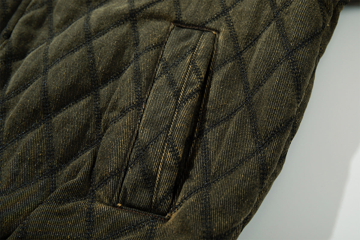 Close-up of the olive green quilted jacket sleeve showing a stitched rectangular pocket