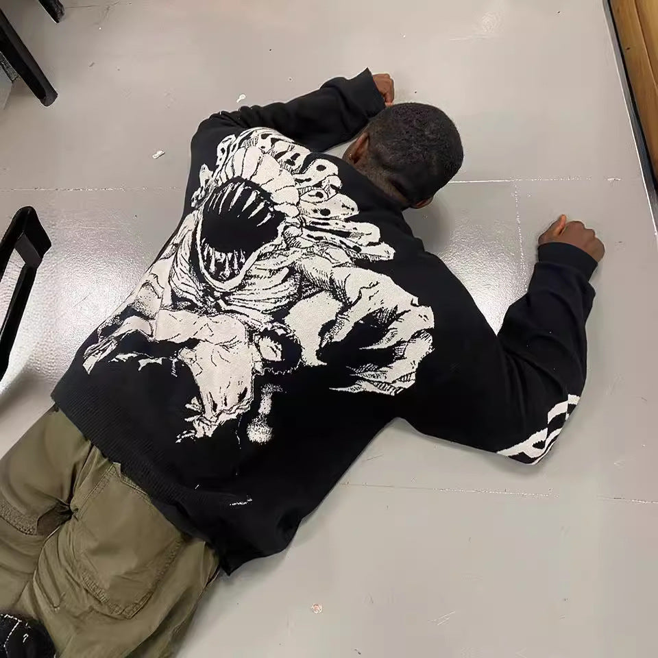 A person is lying face down on the smooth, light-colored floor, wearing a Jujutsu Kaisen Premium Yuta Okkotsu-Inspired Full Knit Sweater. The sweater showcases a striking jacquard design of a monstrous creature on the back, flawlessly merging streetwear fashion with an edgy flair.