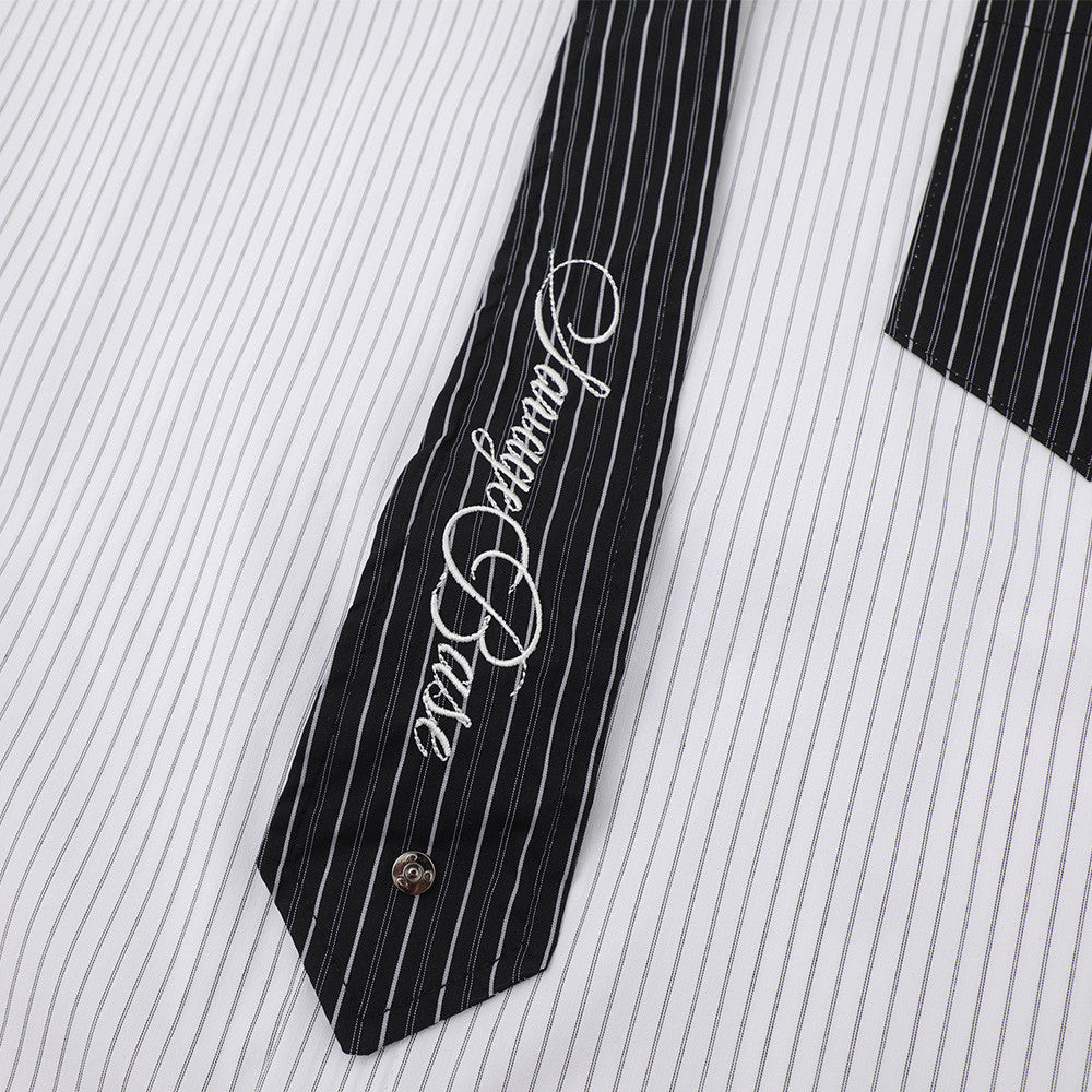 Black contrast tie with white script embroidery on striped shirt front