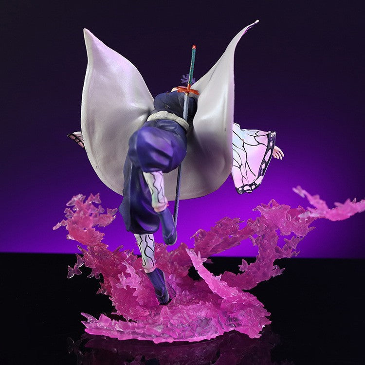 The Demon Slayer Shinobu Kocho Figure, crafted from high-quality PVC and measuring 20cm, showcases the Butterfly Ninja in a dynamic pose with a sword. Clad in a flowing white and purple outfit, purple translucent effects enhance this captivating figure against a dark backdrop.