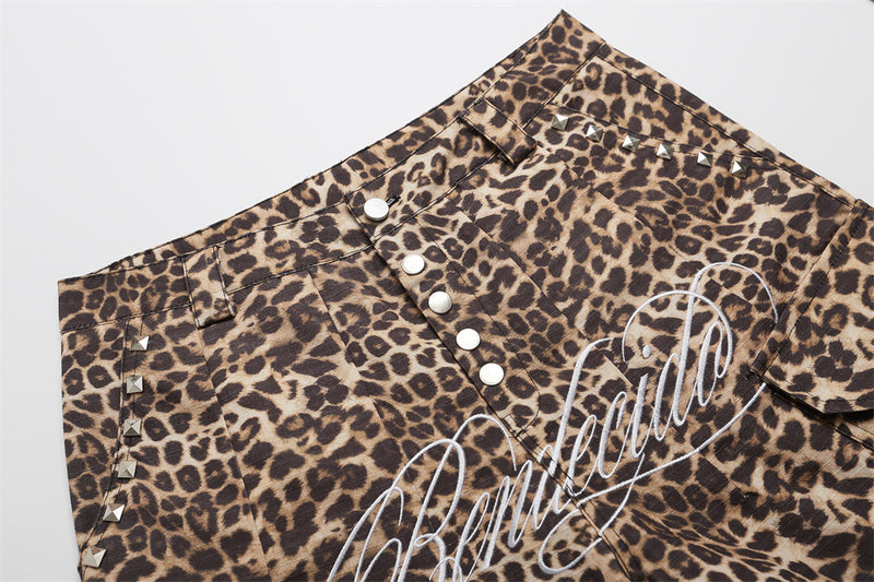 Close-up of leopard print cargo shorts front waist with metal snap buttons and stud details