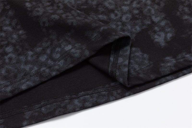 Close-up of the dark mottled shirt hem with a small side slit and visible seam stitching