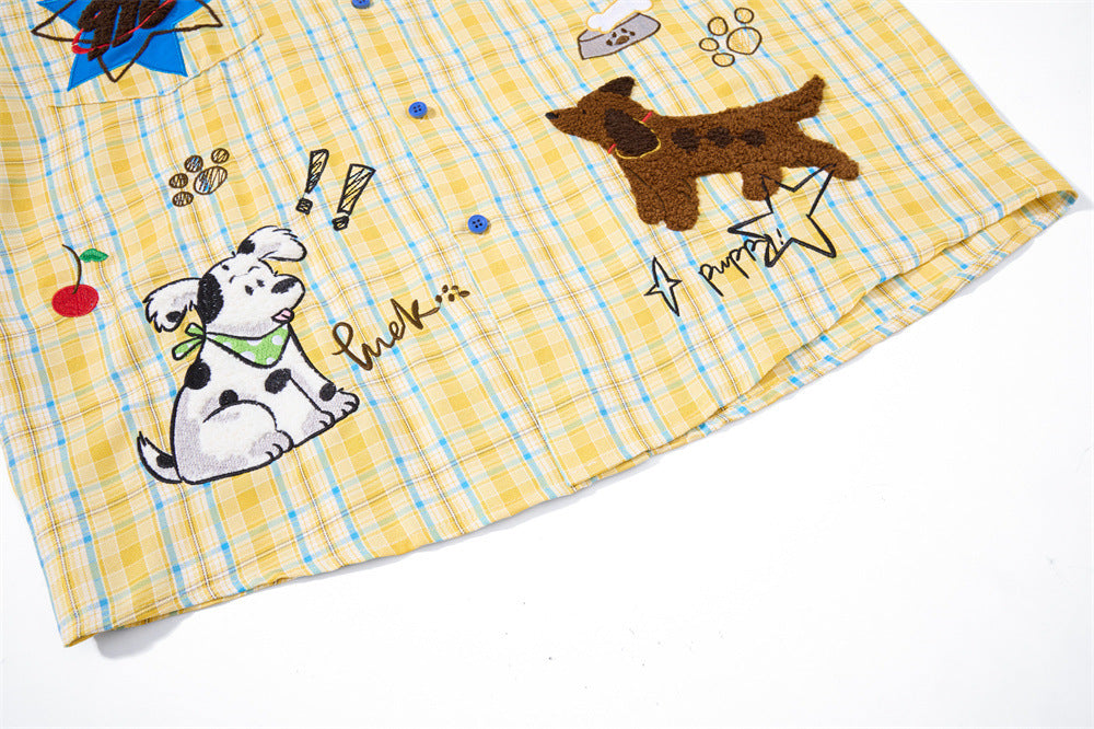Bottom hem of yellow plaid shirt with cartoon dog embroidery on the front