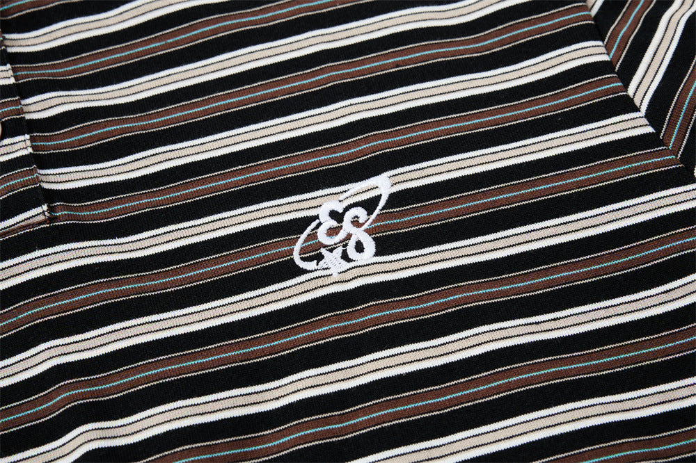 Close-up of embroidered chest logo on black striped Henley shirt