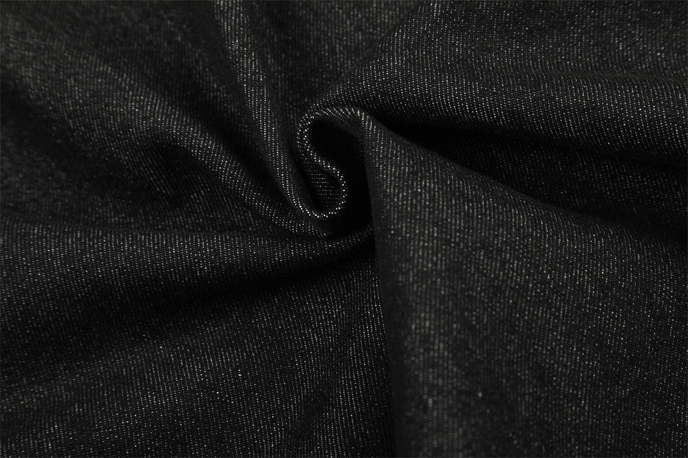 Close-up of black denim fabric texture with gathered fold detail