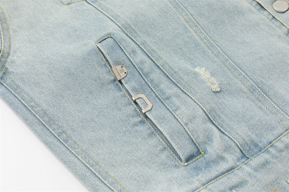 Close-up of a welt pocket opening with metal pull detail and a small distressed denim patch