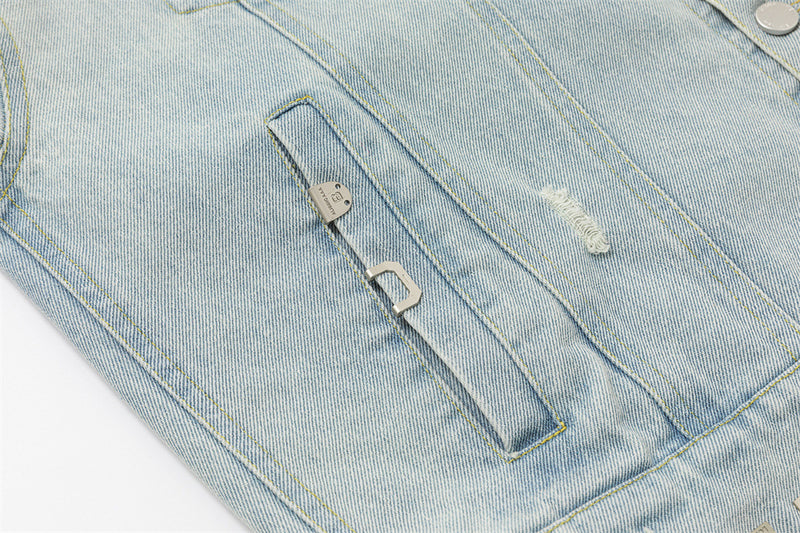 Close-up of a welt pocket opening with metal pull detail and a small distressed denim patch