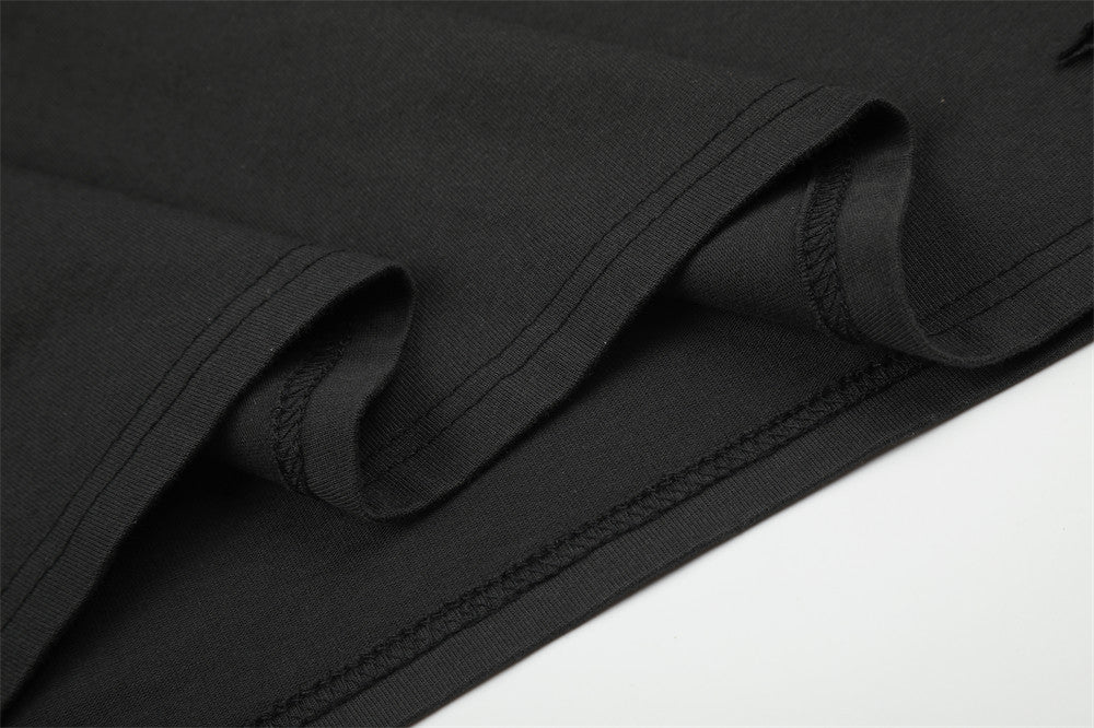 Close-up of black sleeve and hem seams with folded fabric detail