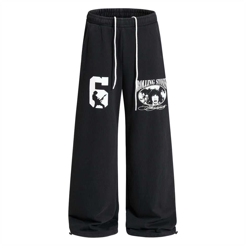 Wide-leg black sweatpants with Rolling Stones band graphic print and number 6 silhouette on front leg panels