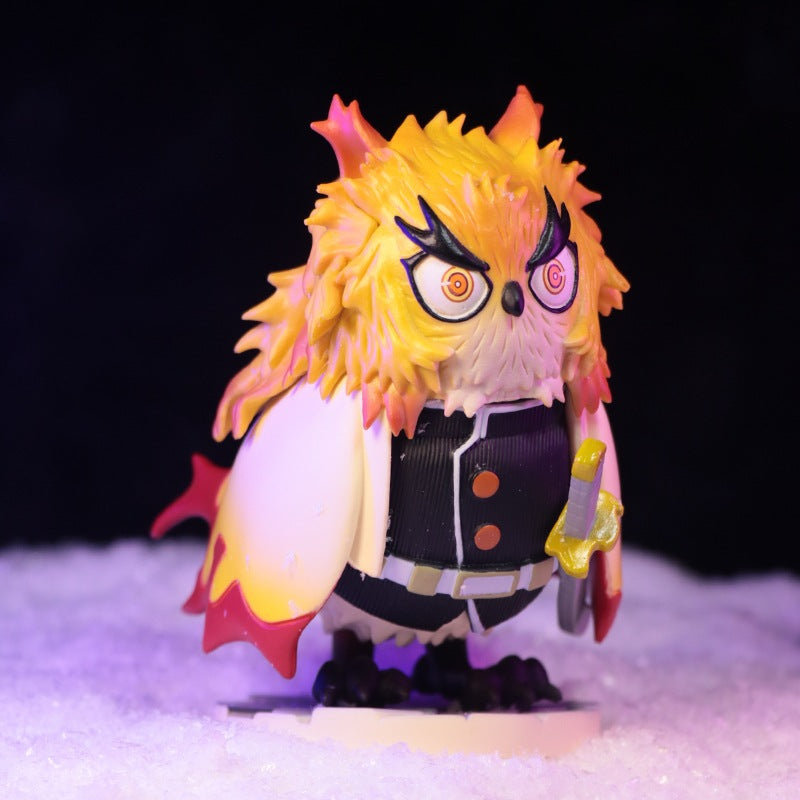 This striking Demon Slayer collectible, the Owl Cosplay Flame Hashira (Kyojuro Rengoku) Figure, showcases an owl in Rengoku style with yellow and orange feathers, fierce eyes, red horns, and a black uniform with a white cape. It wields a yellow sword on a dark backdrop with a snowy base.