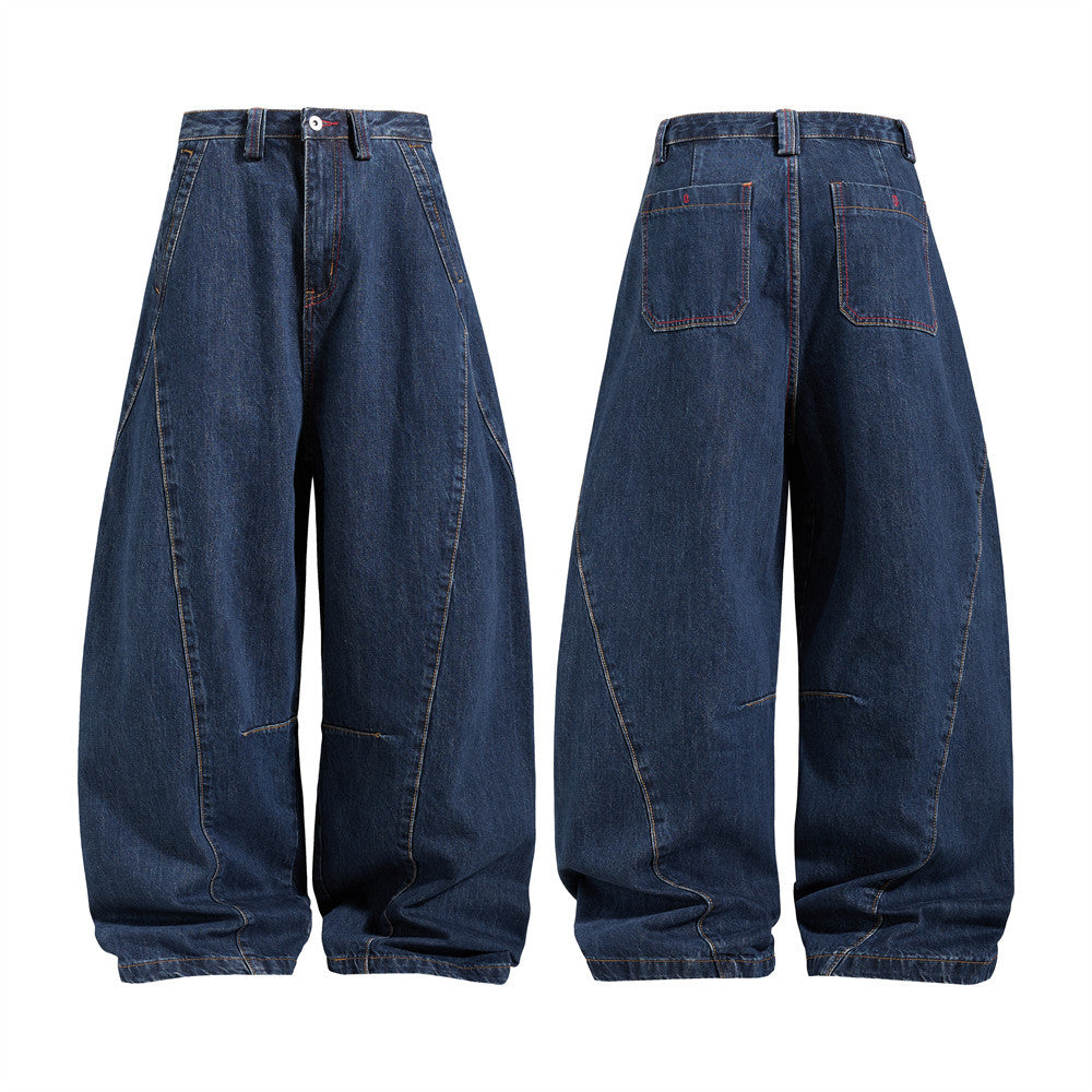 Herrenjeans mit weitem Bein im Barrel-Schnitt aus dunkelindigoblauem Denim, mit dekonstruierter Teilungsnaht und zweifarbigen Kontrastnähten, Vorder- und Rückansicht