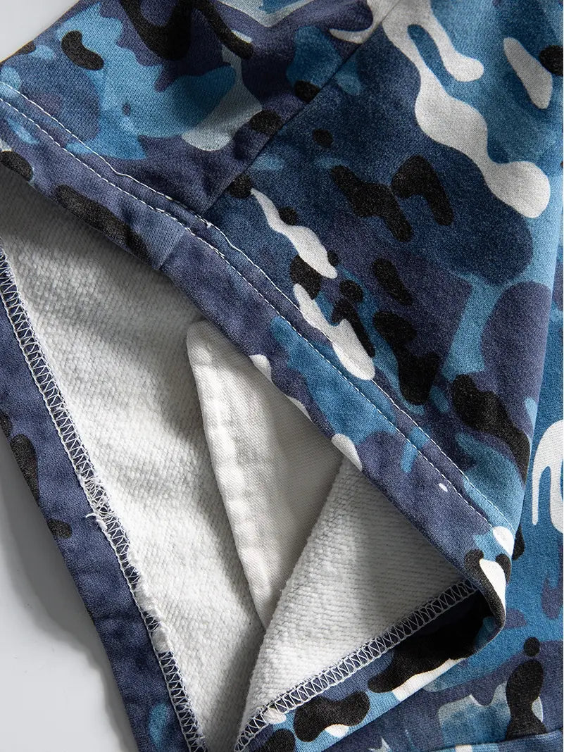 A close-up of the Men's Blue Camo Drawstring Shorts shows blue, black, and white camouflage fabric with a stitched hem and soft white lining—ideal for stylish, relaxed fit cotton shorts or standout streetwear.