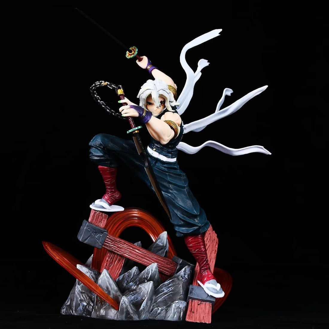 The Tengen Uzui Battle Sound Pillar Figure is a 27cm high-quality PVC collectible from Demon Slayer featuring Tengen with white hair, holding a sword. The figure includes red boots and a dark outfit, posed on a rocky base with a red swirling wave against a black background.