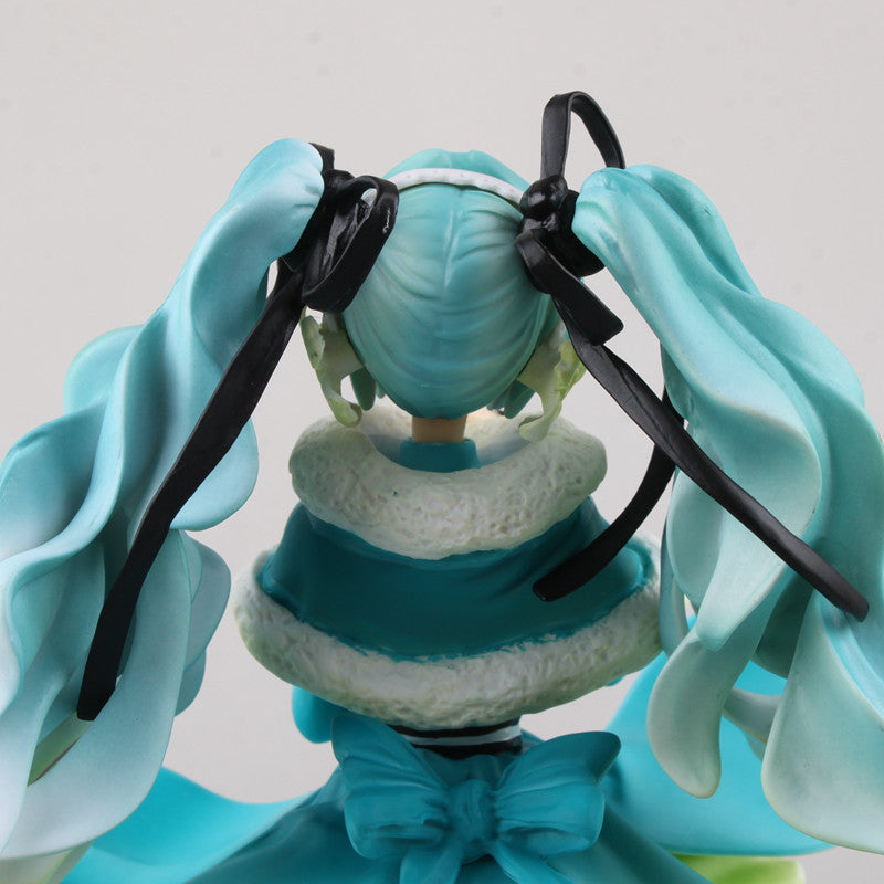 This Hatsune Miku 1/7 scale 28cm PVC figure by Hatsune Miku highlights her iconic teal twin-tails with black ribbons, a headband, teal and white outfit with a fluffy collar, and large rear bow, emphasizing her unique hairstyle and elegant pose.