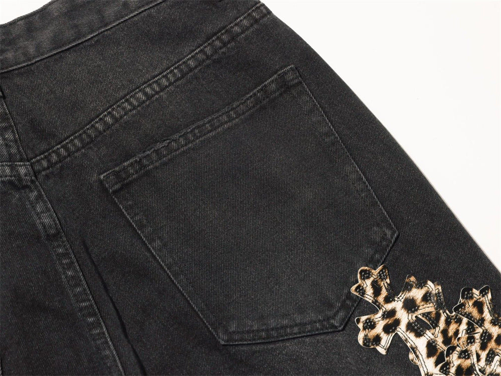 Close-up of back pocket on black jeans with leopard cross patches