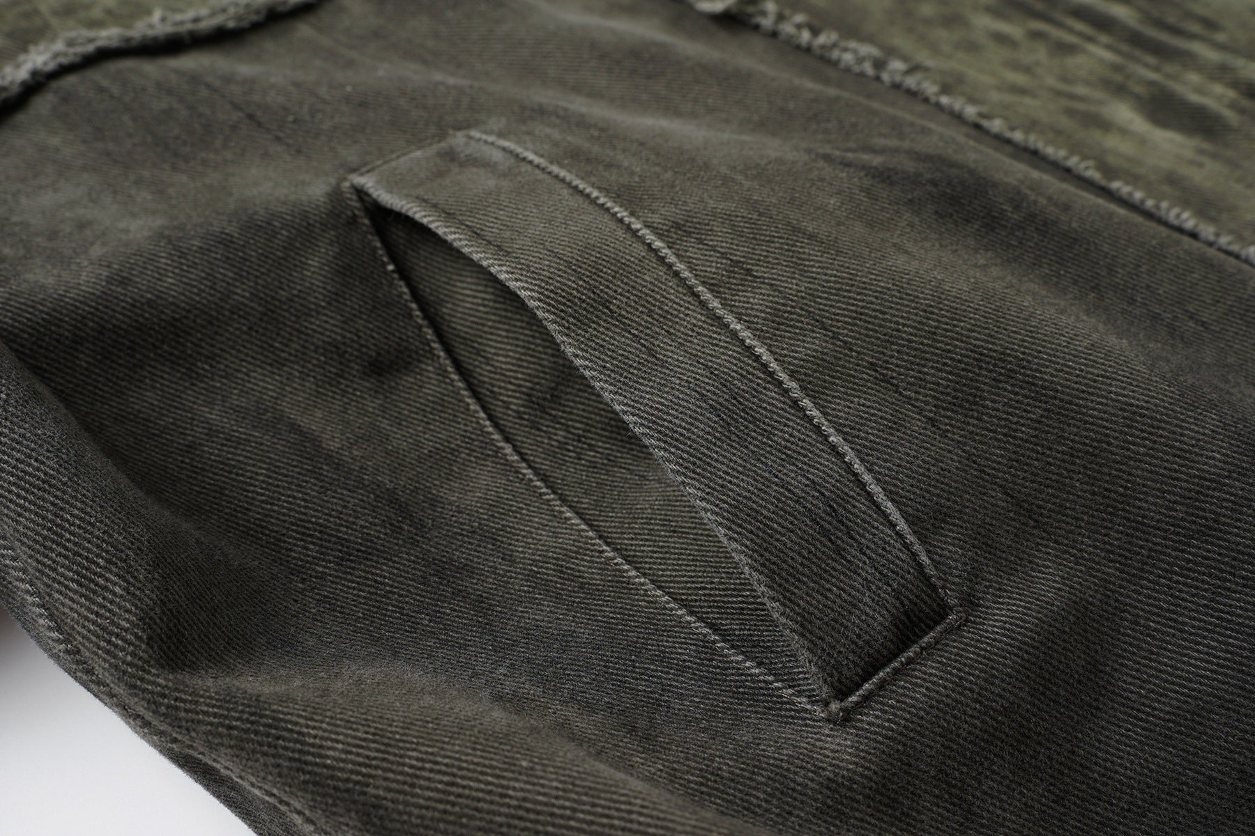 Veste bomber en jean délavé déconstruite à empiècement croisé et coutures effilochées
