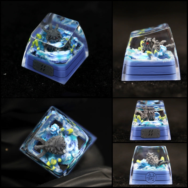 Close-up images showcase a custom keycap from the Tailed Beasts Naruto Keycaps Collection, featuring a sculpted gray creature with red eyes in an aquatic design. It includes blue water and yellow accents, encased in clear resin.