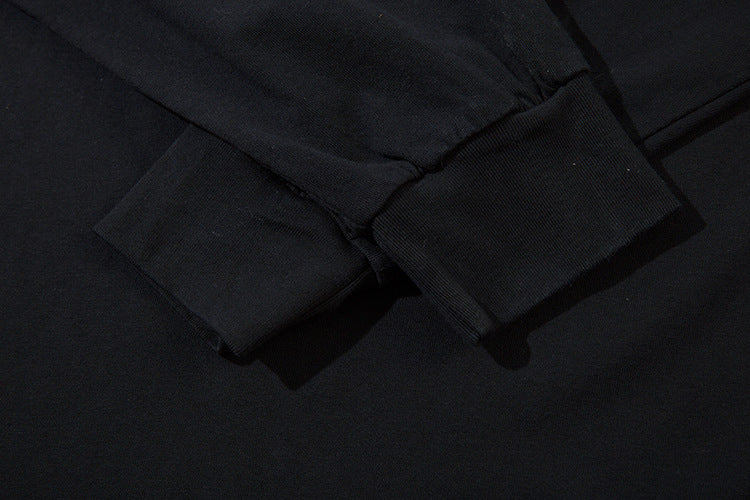 Close-up of the cuff on a Limited Edition Death Note Long Sleeve Shirt - Black &amp; Gray Gradient. The smooth fabric shows visible stitching, with lighting creating slight shadows that highlight the texture of this artistic hem piece from the Death Note brand.
.