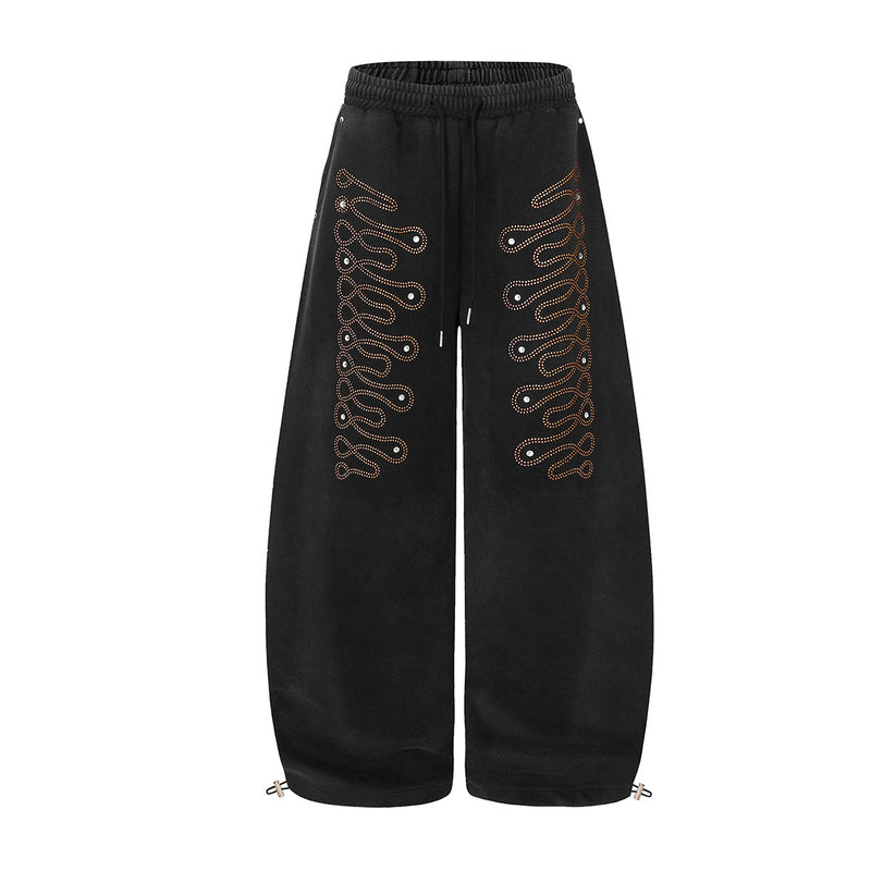 Wide-leg washed black sweatpants with orange rhinestone wave pattern on both legs, elastic drawstring waist and ankle toggle