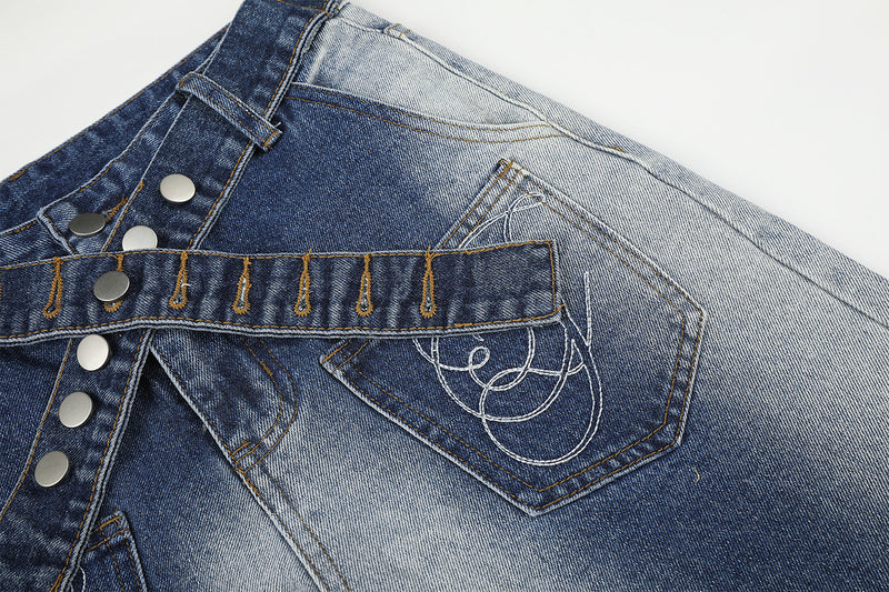 Vaqueros baggy de pierna ancha con cinturilla cruzada de broches y bolsillos bordados