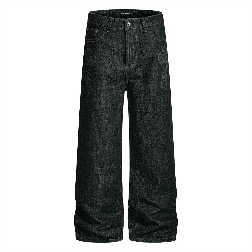 Men's wide-leg black denim jeans with tonal dragon embroidery on front thigh, straight-leg silhouette, front and back view