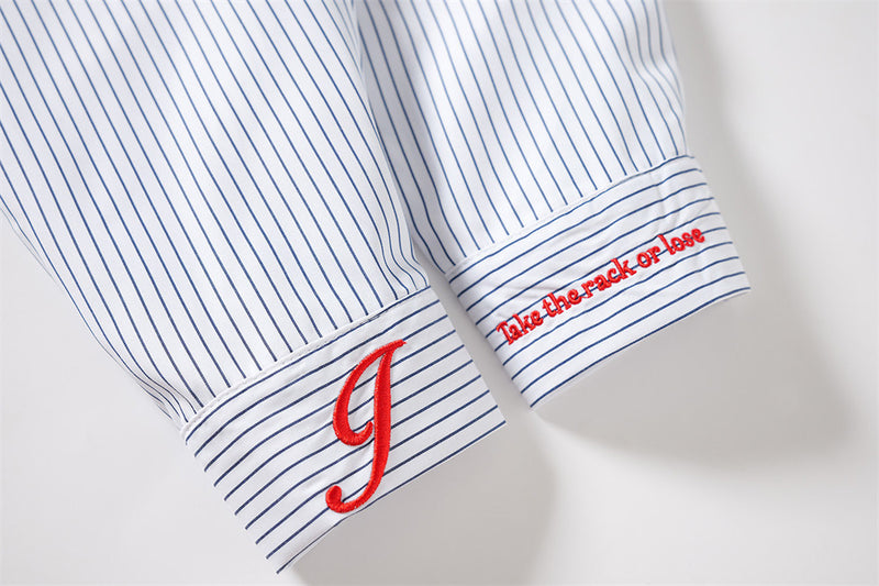Close-up of striped cuffs with red embroidered letter and small slogan text