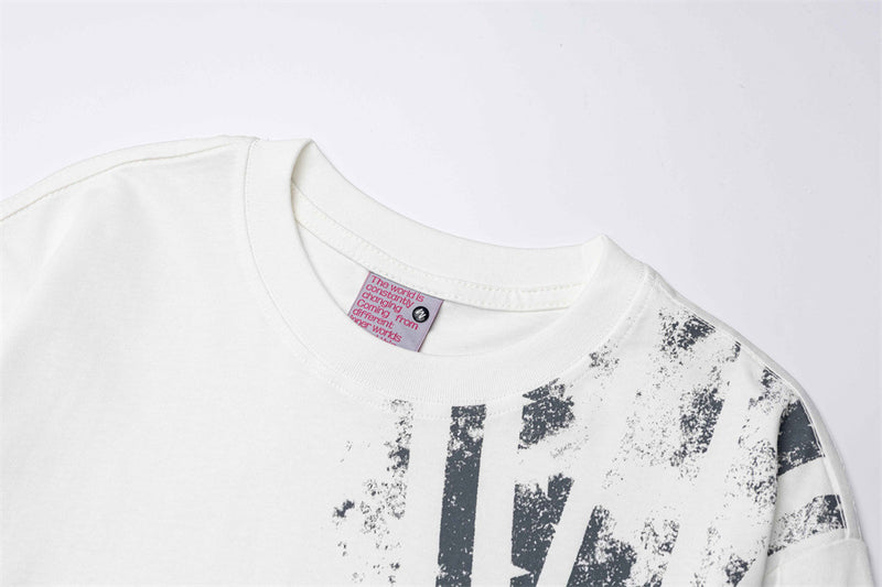 White crew neck tee collar and shoulder close-up with distressed black Union Jack print