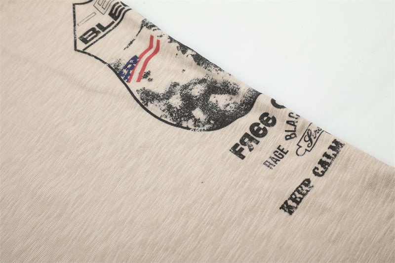 Diagonal close-up of beige tee graphic print with text along the side