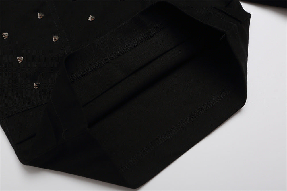 Close-up of black shorts lower leg with studded front panel and layered hem