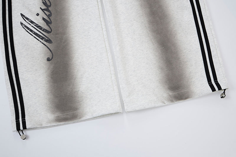 Pantalon de survêtement ample à jambes larges avec bandes latérales, fausse double ceinture et imprimé graphique