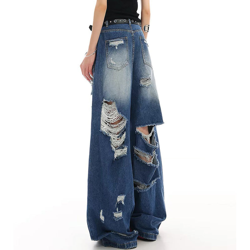 Back view of wide-leg blue jeans with large distressed rips on a model