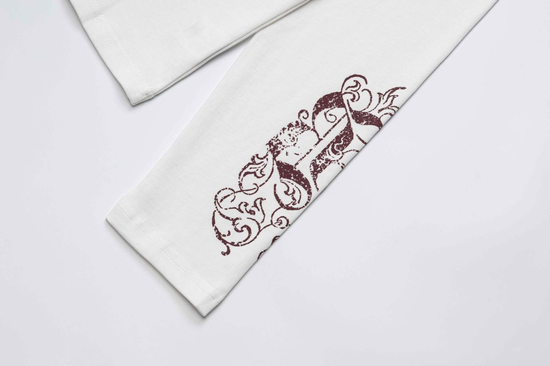 Camiseta de manga larga con cruz de tachuelas y estampado de calaveras en las mangas