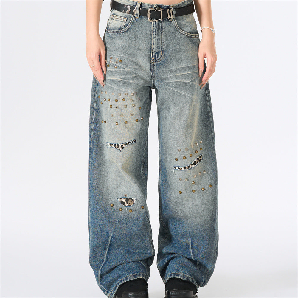 Men's wide-leg distressed jeans with antique brass studs and leopard-print rip patches in gradient washed blue denim
